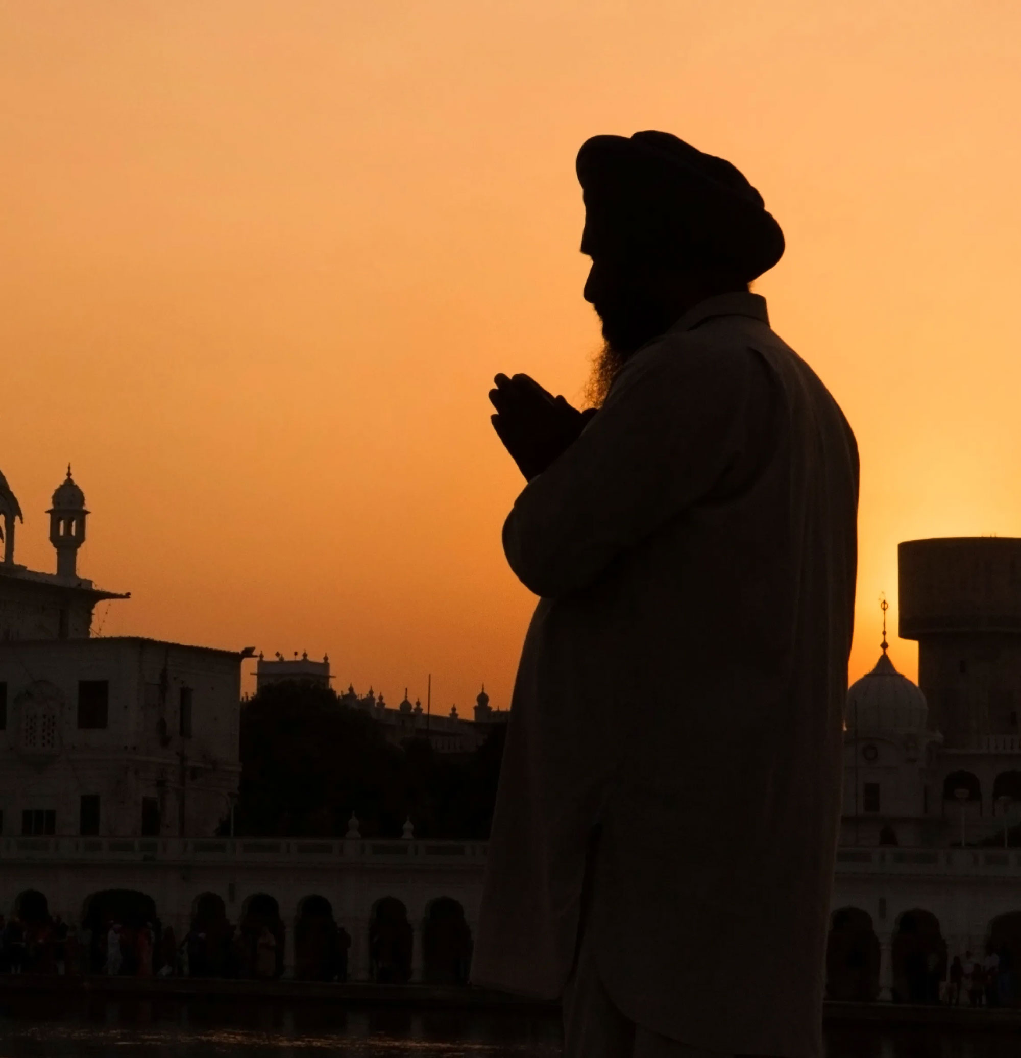Silhouette of a person in prayer at sunset